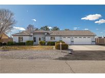 Charming single-story home featuring a three-car garage, manicured landscaping and tile roof at 320 Cimmarron Pl, Pahrump, NV 89048