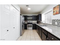 Modern kitchen featuring stainless steel appliances, granite counters, and tiled backsplash at 5166 Silverheart Ave, Las Vegas, NV 89142