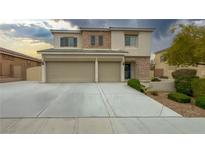 Charming two-story home showcasing a well-manicured lawn, stone accents, and a spacious three-car garage at 780 Flowing Meadow Dr, Henderson, NV 89014