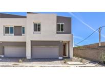 Modern two-story home featuring a gray garage door and neutral paint, complemented by a well-paved driveway at 8629 Ensworth St # 111, Las Vegas, NV 89123
