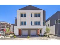 Modern two-story home featuring gray and white facade, and an attached two-car garage with grey doors at 8629 Ensworth St # 114, Las Vegas, NV 89123
