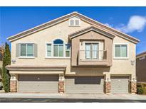 Inviting multi-level townhome with three-car garage, balcony, and neutral-toned stucco exterior at 8798 Tom Noon Ave # 103, Las Vegas, NV 89178