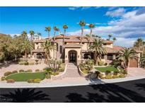 Elegant home exterior boasts a grand entrance, beautiful landscaping, and multiple palm trees at 2540 Red Arrow Dr, Las Vegas, NV 89135