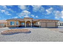 Beautiful single-story home with stucco exterior, stone accents, three-car garage, and desert landscaping at 3080 S Prairie Ave, Pahrump, NV 89048