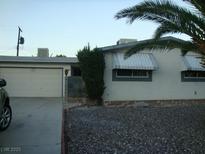 Modest single story home featuring a two-car garage, desert landscaping, and canvas awnings at 313 View Dr, Las Vegas, NV 89107