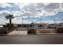 Charming home featuring a gated yard, rock accents, and mature palm trees for added curb appeal at 4701 Sacks Dr, Las Vegas, NV 89122