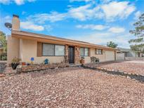 Cozy single-story home featuring neutral stucco, desert landscaping, and a chimney against a sunny sky at 6513 Painted Desert Dr, Las Vegas, NV 89108