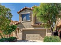 Two-story home features a well-maintained lawn, mature trees, and an attached two-car garage at 9013 Semillon St, Las Vegas, NV 89148