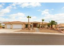 Sprawling single-story home featuring three-car garage, tile roof, desert landscaping and palm trees at 1056 Calico Ridge Dr, Henderson, NV 89011