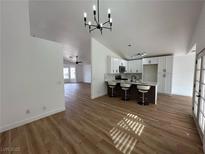 Open-concept kitchen and dining area with modern lighting and wood flooring at 1183 Winnipeg Ct, Henderson, NV 89002