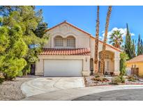 Charming two-story home with a tile roof, two-car garage, and desert landscaping in front yard at 2700 Brienza Way, Las Vegas, NV 89117