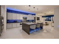 Bright, modern kitchen featuring a large island, stainless steel appliances, and blue-lit backsplash at 4087 Villa Rafael Dr, Las Vegas, NV 89141