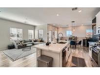 Open-concept living room features a modern kitchen with stainless steel appliances and a cozy living area at 524 Teovani St # 826, Henderson, NV 89052