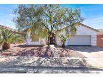 Charming single-story home with desert landscaping, mature tree, and a two-car garage enhancing curb appeal at 531 Coolidge Ave, Henderson, NV 89015