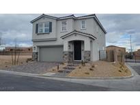 Charming two-story home with a stone-accented facade, well-manicured landscaping, and a two-car garage at 5766 Remy Rain St, Las Vegas, NV 89148