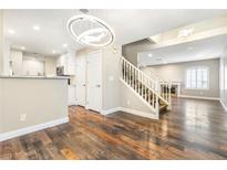 Inviting living room featuring wood floors, modern lighting, and staircase access to upper level at 8224 Crystal Star Ct, Las Vegas, NV 89145