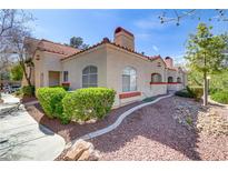 Charming single-story home with red tile roof, lush landscaping, and sidewalk at 8408 Running Deer Ave # 103, Las Vegas, NV 89145