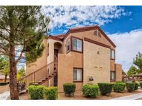 Charming two-story condo with landscaped yard and staircase leading to the front door at 9580 W Reno Ave # 211, Las Vegas, NV 89148