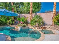 Beautiful pool with lush tropical landscaping and rock waterfall features for resort-style living at 1516 Barrington Oaks St, North Las Vegas, NV 89084