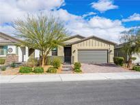 Charming single-story home showcasing a desert landscape, a two-car garage and a welcoming front entrance at 2376 Thelen Ave, North Las Vegas, NV 89086
