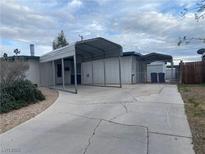 Exterior view of a single-story home showing a carport and a cracked driveway at 3100 Sequoia Ave, Las Vegas, NV 89101