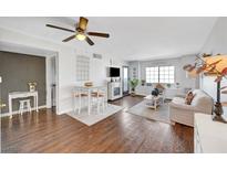 Bright living room featuring wood floors, ceiling fan, dining table, and comfortable seating at 3125 N Buffalo Dr # 1105, Las Vegas, NV 89128