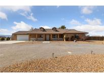 Charming single-story home features a well-maintained yard, inviting curb appeal, and an attached garage at 3450 Oakleaf Ave, Pahrump, NV 89048