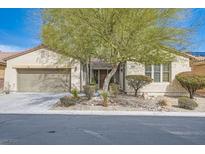 Charming single-story home with desert landscaping, attached garage, and vibrant greenery at 4408 Oasis Hill Ave, North Las Vegas, NV 89085