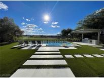 Sparkling pool with lounge chairs and a clear blue sky, perfect for relaxation and outdoor entertainment at 5 Clear Crossing Trl, Henderson, NV 89052