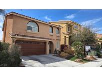 Charming two-story home boasts a well-manicured lawn, desert landscaping and a brown two-car garage at 6007 Sonoma Station Ave, Las Vegas, NV 89139