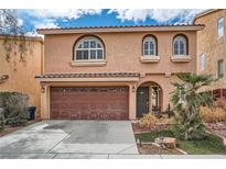 Inviting two-story home featuring a two-car garage, arched windows, and a beautifully landscaped front yard at 6007 Sonoma Station Ave, Las Vegas, NV 89139