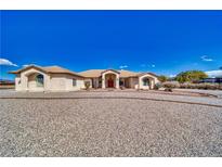 Expansive single-story home with a gravel driveway and well-maintained desert landscaping at 660 Indian Rd, Pahrump, NV 89048