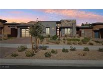 Beautiful modern home with landscaped front yard and neutral colored exterior, complemented by a driveway and two-car garage at 9938 Regency Canyon Way, Las Vegas, NV 89148