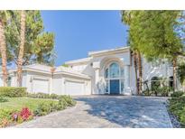Elegant two-story home featuring a blue double-door entry, white exterior, and a three-car garage at 2339 Prometheus Ct, Henderson, NV 89074