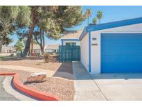 Charming home featuring a blue garage door, complemented by trees and a well-maintained yard at 4032 Great Plains Way, Las Vegas, NV 89121