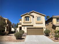 Two-story stucco home with an attached garage, manicured landscaping and a concrete driveway at 405 Center Green Dr, Las Vegas, NV 89148