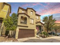Two-story home with a two-car garage and a cozy front porch, enhanced by lush landscaping at 8932 Jaquita Ave, Las Vegas, NV 89149