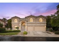 Two-story home with a symmetrical facade, arched windows, manicured landscaping and a three-car garage at 1923 Grey Eagle St, Henderson, NV 89074