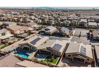 Expansive aerial view of a community highlighting homes with pools and solar panels against a backdrop of the Las Vegas skyline at 6217 Starflare St, Las Vegas, NV 89148