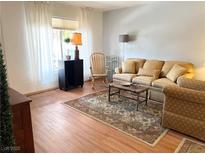 Warm living room features hardwood floors, large window, neutral colors and traditional furnishings at 625 S Royal Crest Cir # 2, Las Vegas, NV 89169