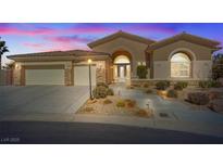Charming single-story home with desert landscaping, a three-car garage, and a grand arched entryway at 6772 Running Colors Ave, Las Vegas, NV 89131