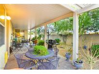 Inviting covered patio perfect for outdoor dining with metal table and chairs and BBQ grill at 7172 Painted Paradise St, Las Vegas, NV 89131