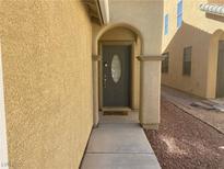 Inviting front entrance with an arched doorway and stylish gray door at 8329 Brilliant Ruby Ct, Las Vegas, NV 89139
