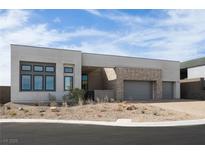 Modern home featuring stone accents, a two-car garage, and desert landscaping at 10921 Rossa Peak Ave, Las Vegas, NV 89135