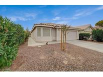 Charming single-story home featuring a tiled roof, low maintenance landscaping, and an attached two-car garage at 1115 Pearl Marble Ave, North Las Vegas, NV 89081