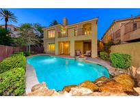 Inviting backyard pool with a rock waterfall feature and cozy seating area, perfect for relaxation and outdoor entertaining at 2 Cerchio Centrale, Henderson, NV 89011