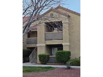 Inviting exterior view of a two-story condo with private balcony and well-maintained landscaping at 2300 E Silverado Ranch Blvd # 2074, Las Vegas, NV 89183