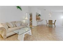 Bright living room features modern glass table, open layout to kitchen and dining area at 3660 Renovah St # 204, Las Vegas, NV 89129