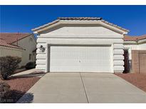 Exterior shot of the home's garage with a large driveway and well-maintained landscaping at 3761 Tohono Canyon St, Las Vegas, NV 89147