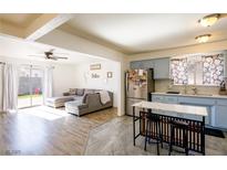 Bright living room featuring a gray sectional couch, sliding glass doors, and view into the kitchen at 4116 E Ogden Ave, Las Vegas, NV 89110